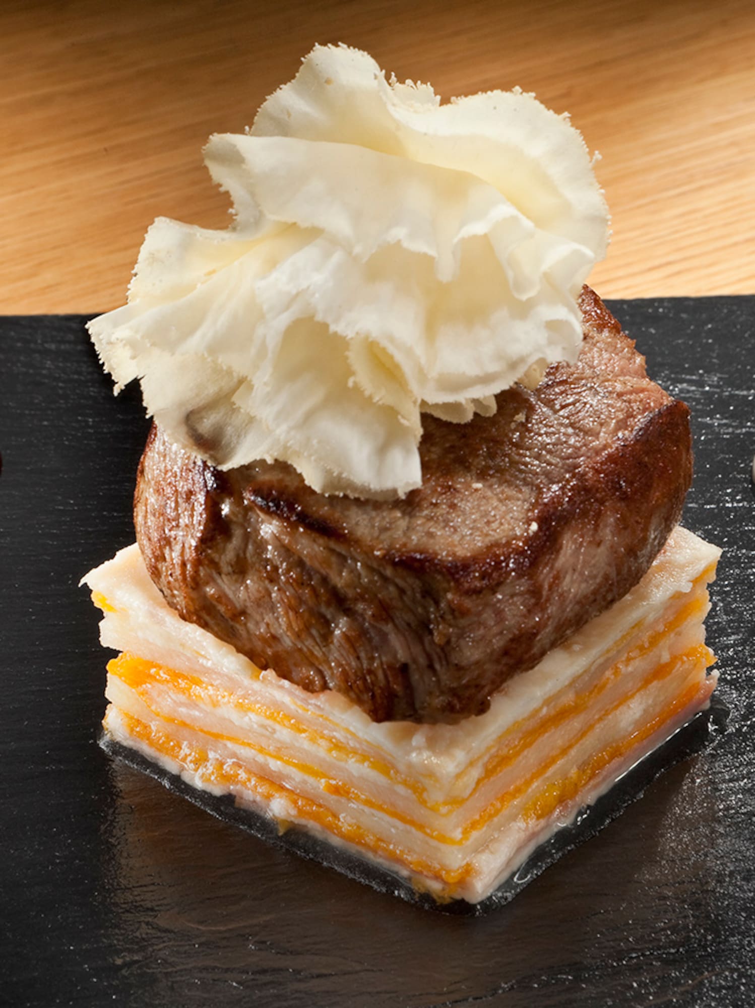 a piece of meat with cheese and sauce on top