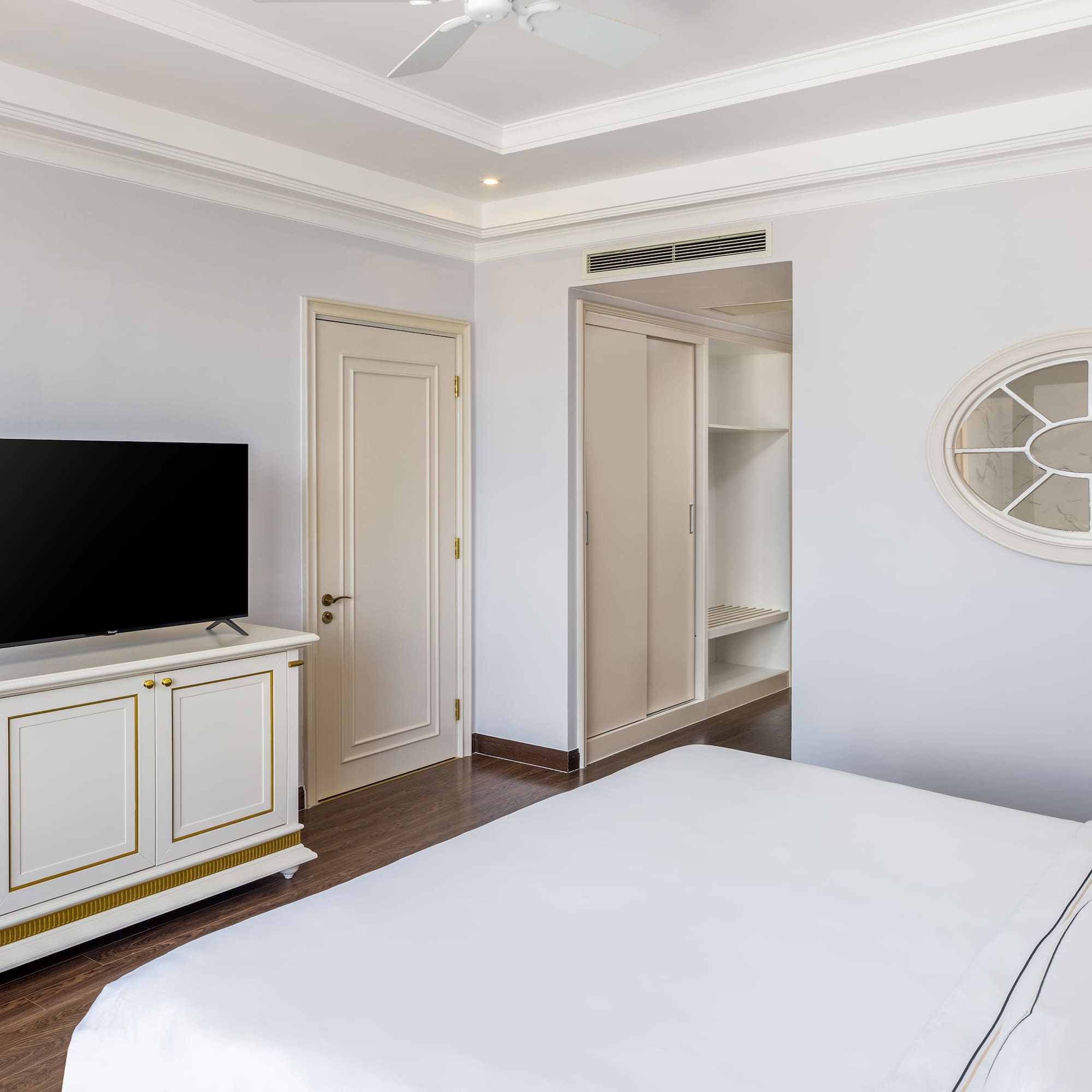 a bedroom with a tv and a white bed