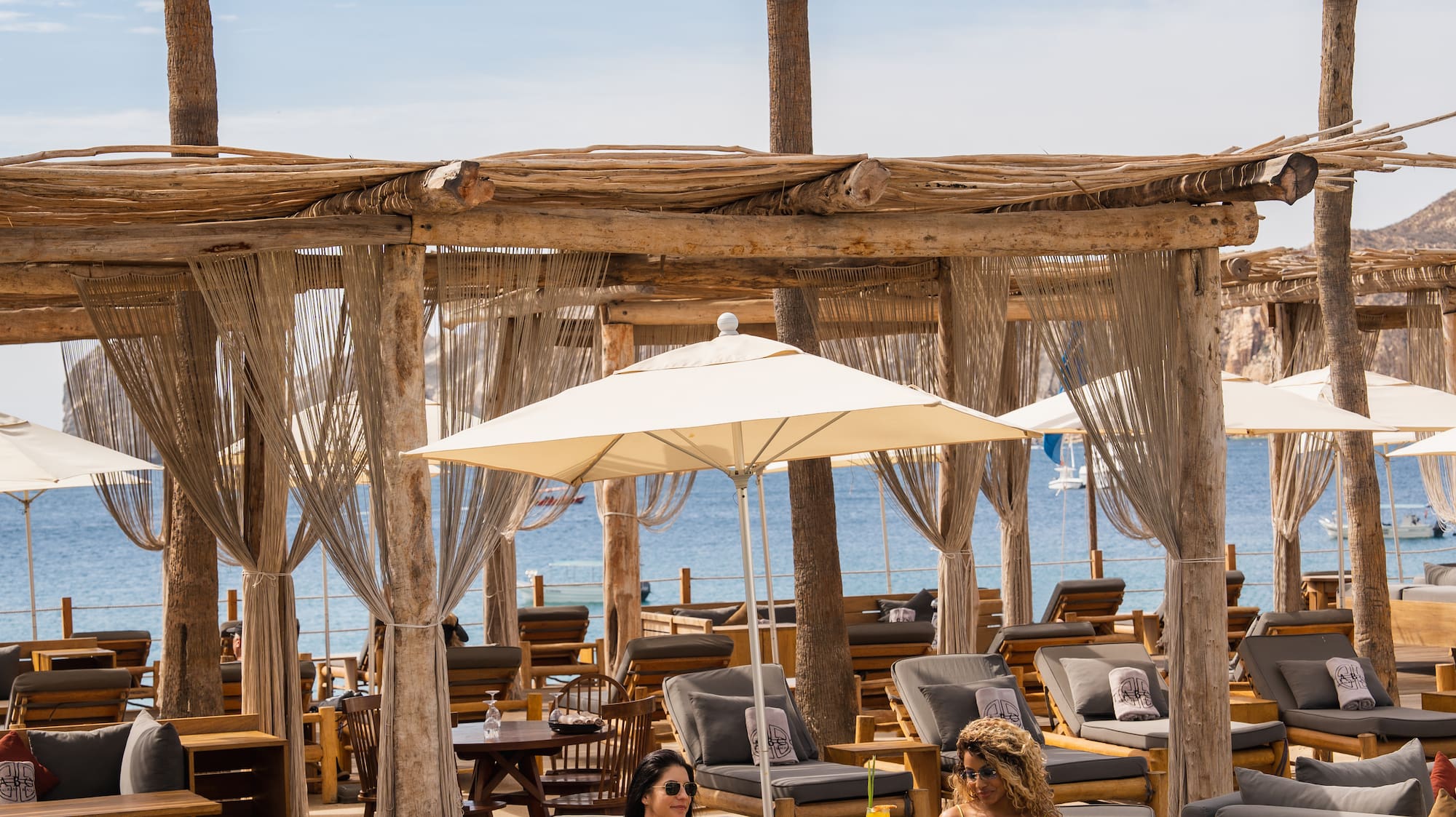 a group of people sitting on lounge chairs under umbrellas