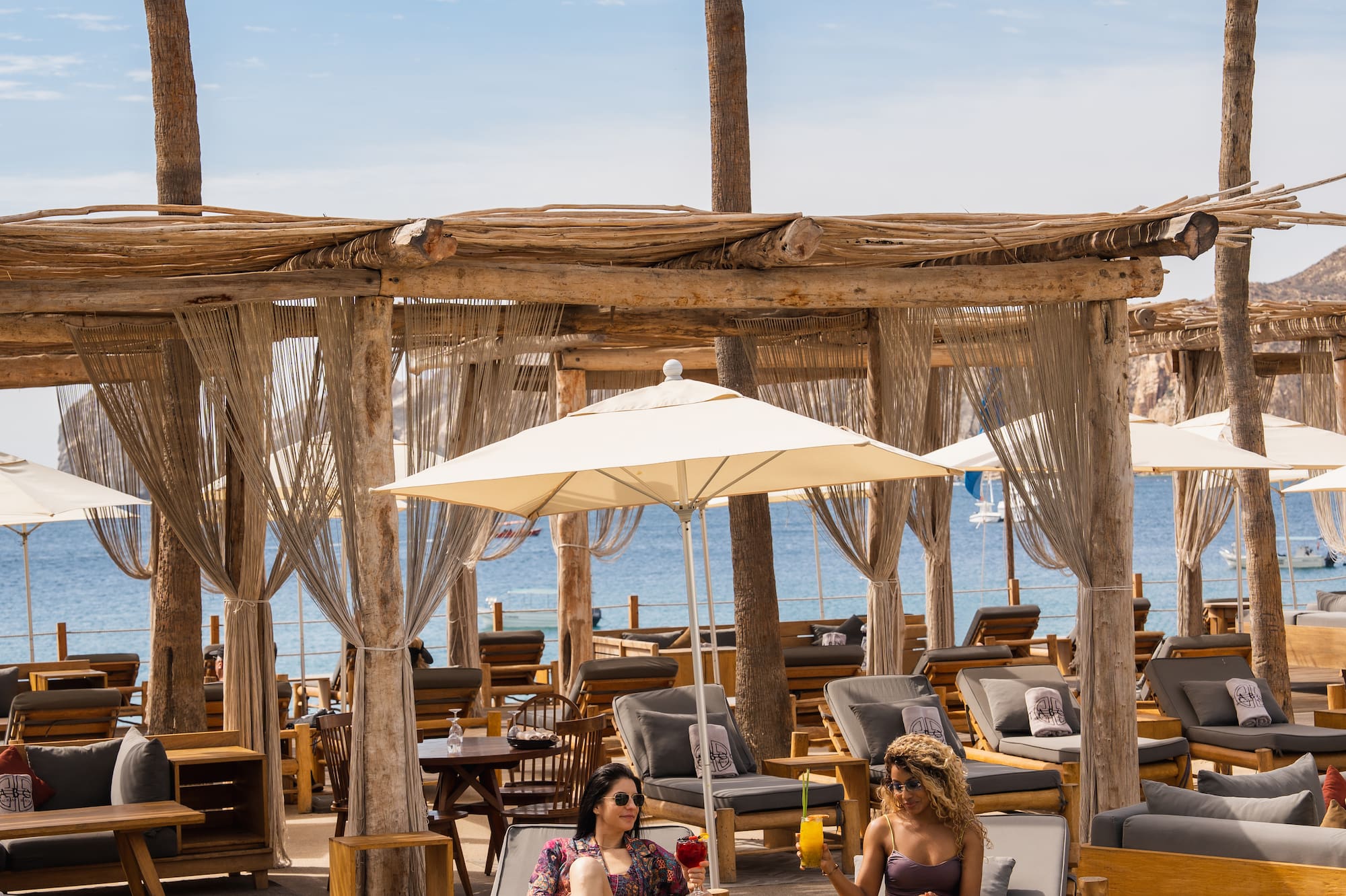 a group of people sitting on lounge chairs under umbrellas