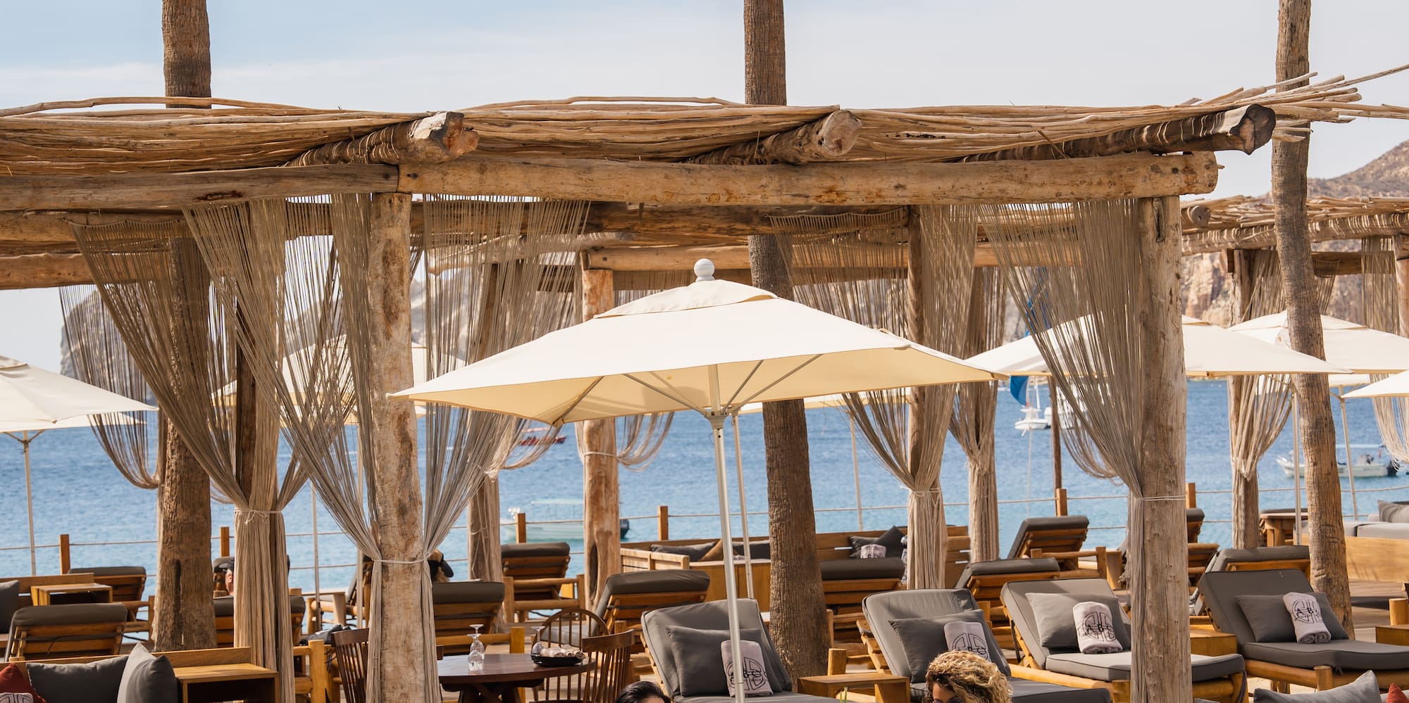 a group of people sitting on lounge chairs under umbrellas