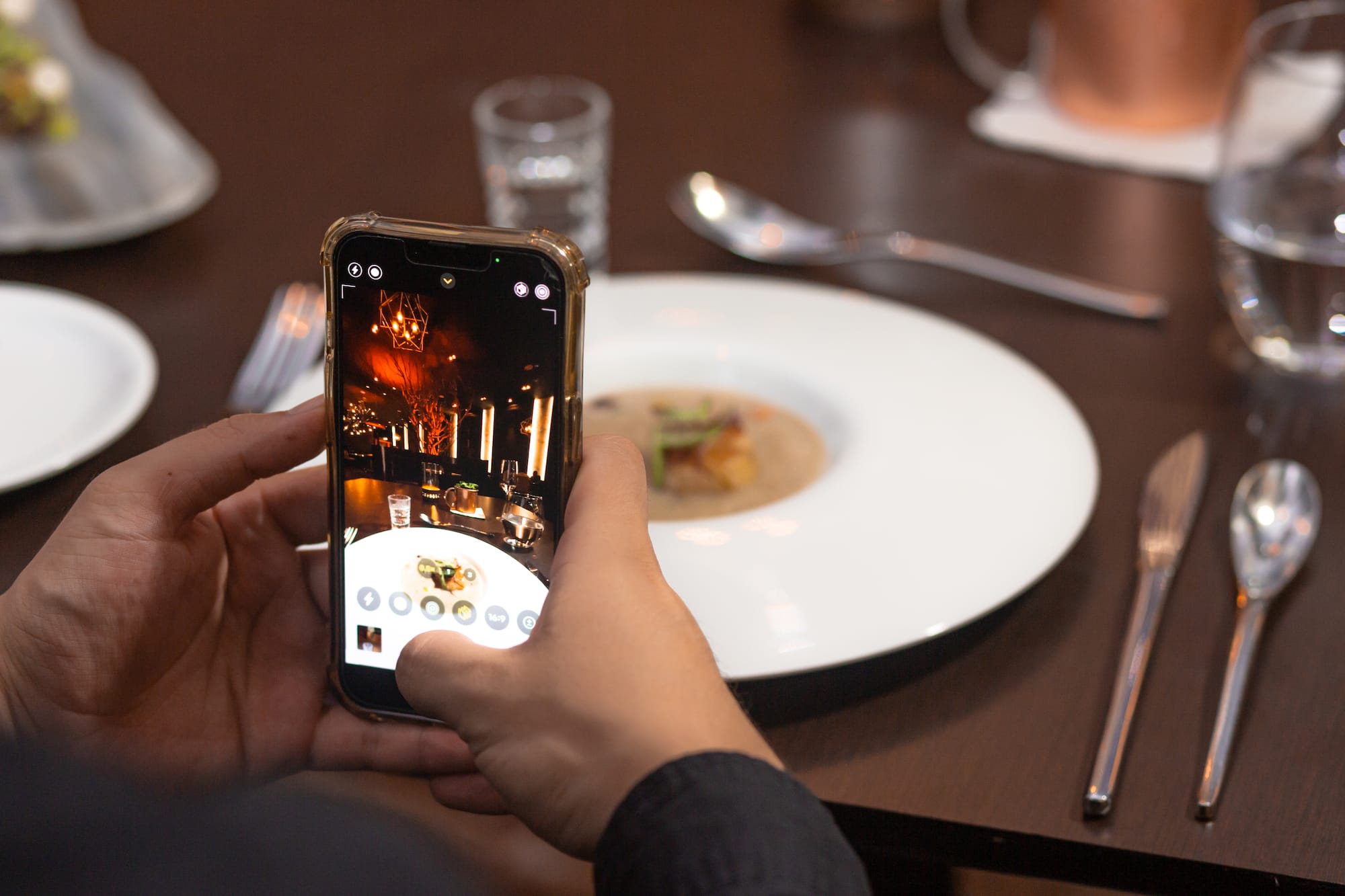 a person taking a picture of food on a plate