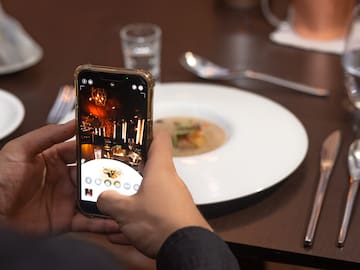 a person taking a picture of food on a plate