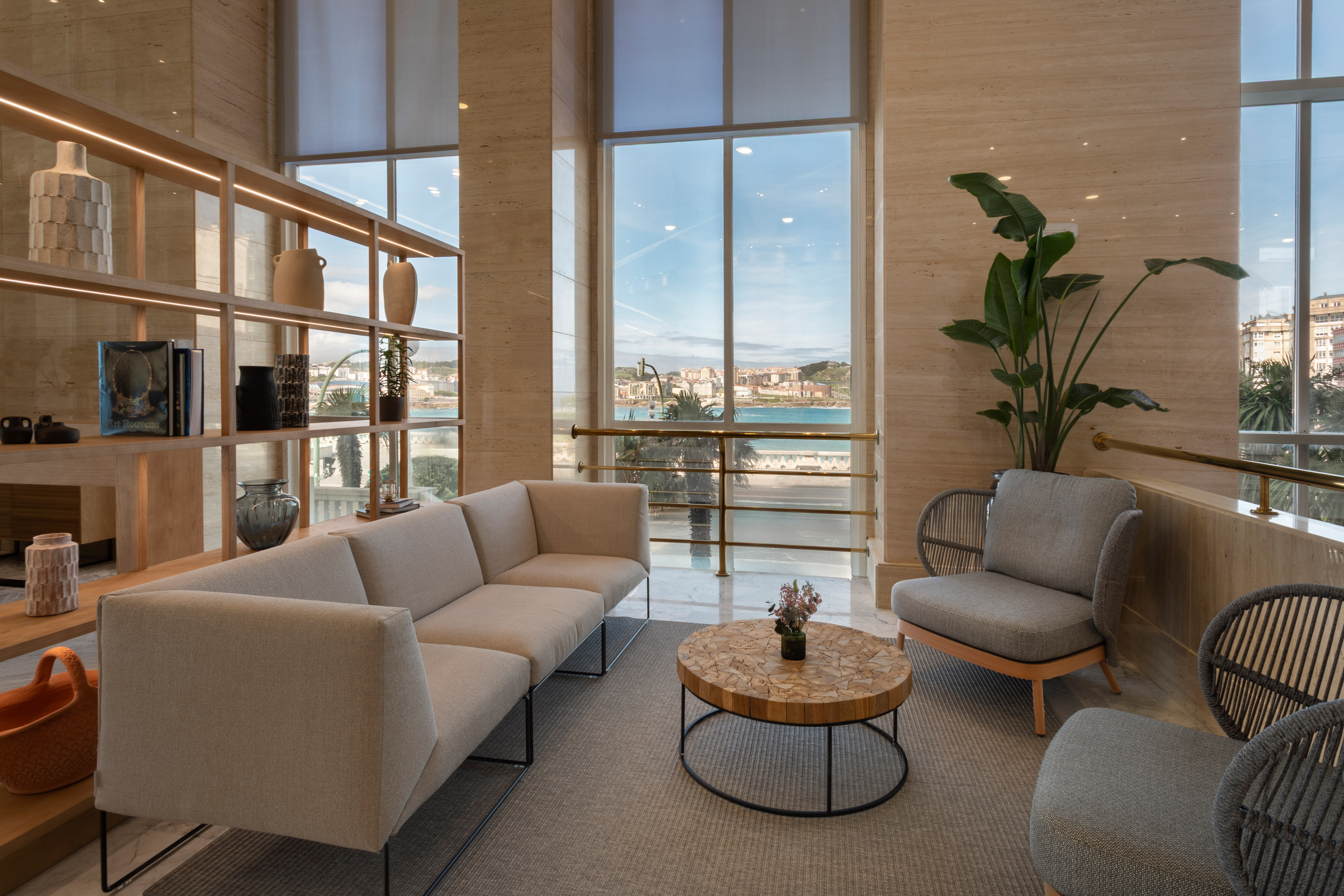 Luxury hotel lounge with city and bay view, modern furniture, wooden decor.