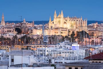 a large castle with many towers and many boats in a harbor