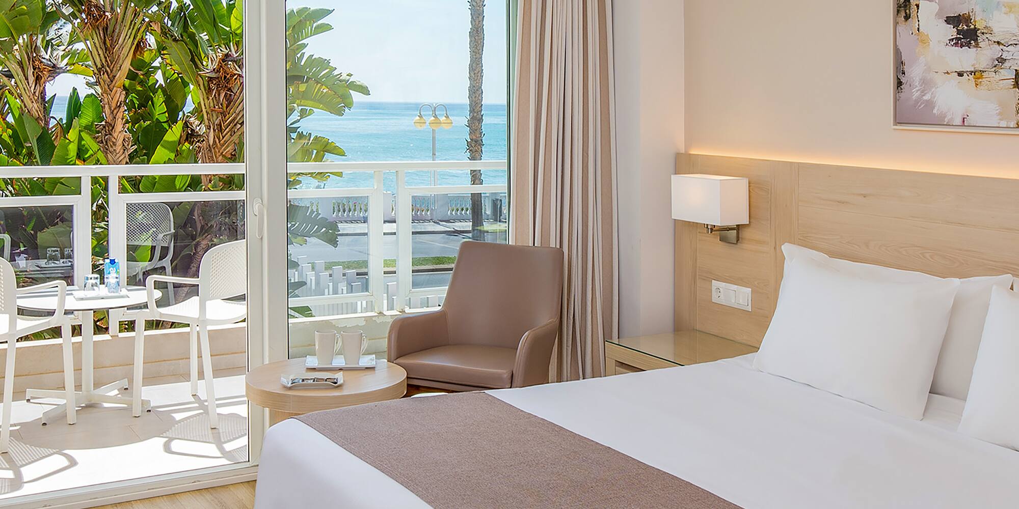 a bedroom with a large bed and a glass door