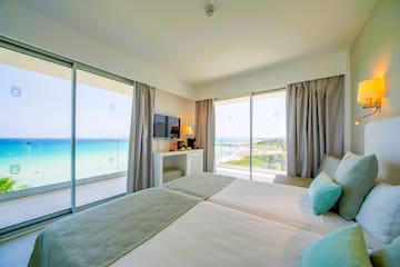 a bedroom with a large window overlooking the ocean