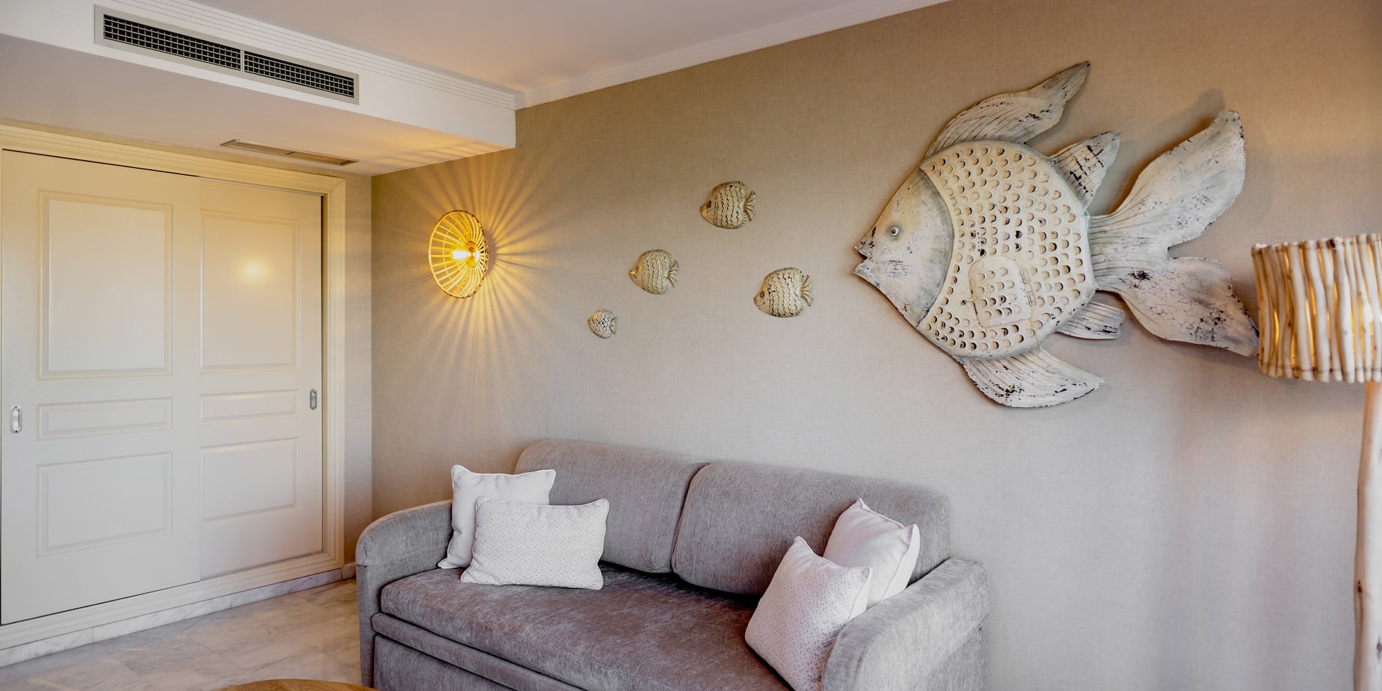 a couch with pillows and a fish on the wall