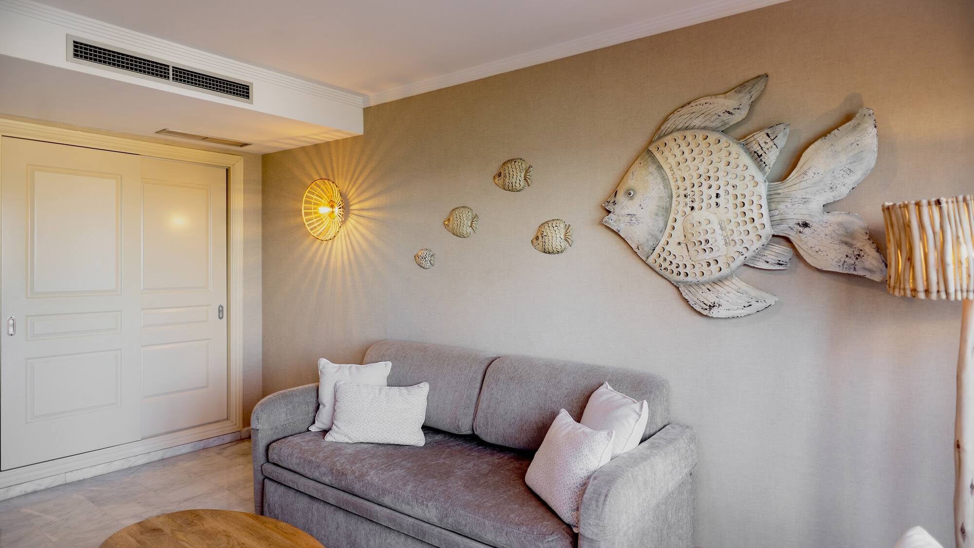 a couch with pillows and a fish on the wall