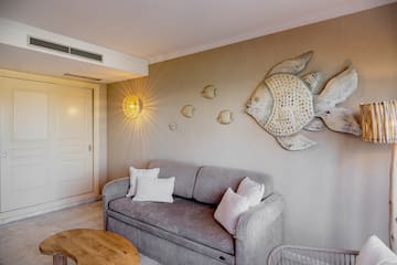 a couch with pillows and a fish on the wall