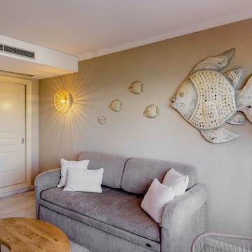 a couch with pillows and a fish on the wall