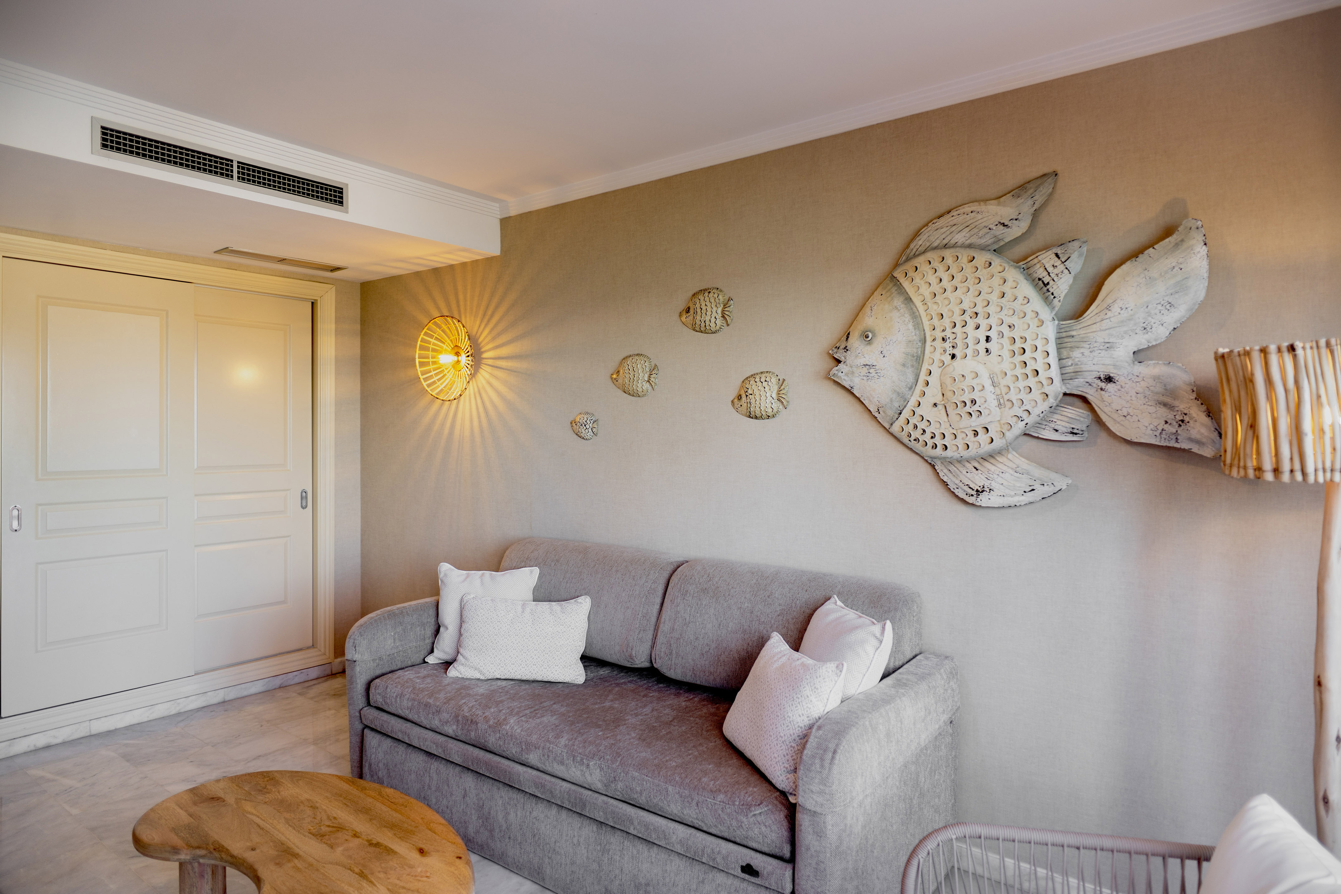 a couch with pillows and a fish on the wall