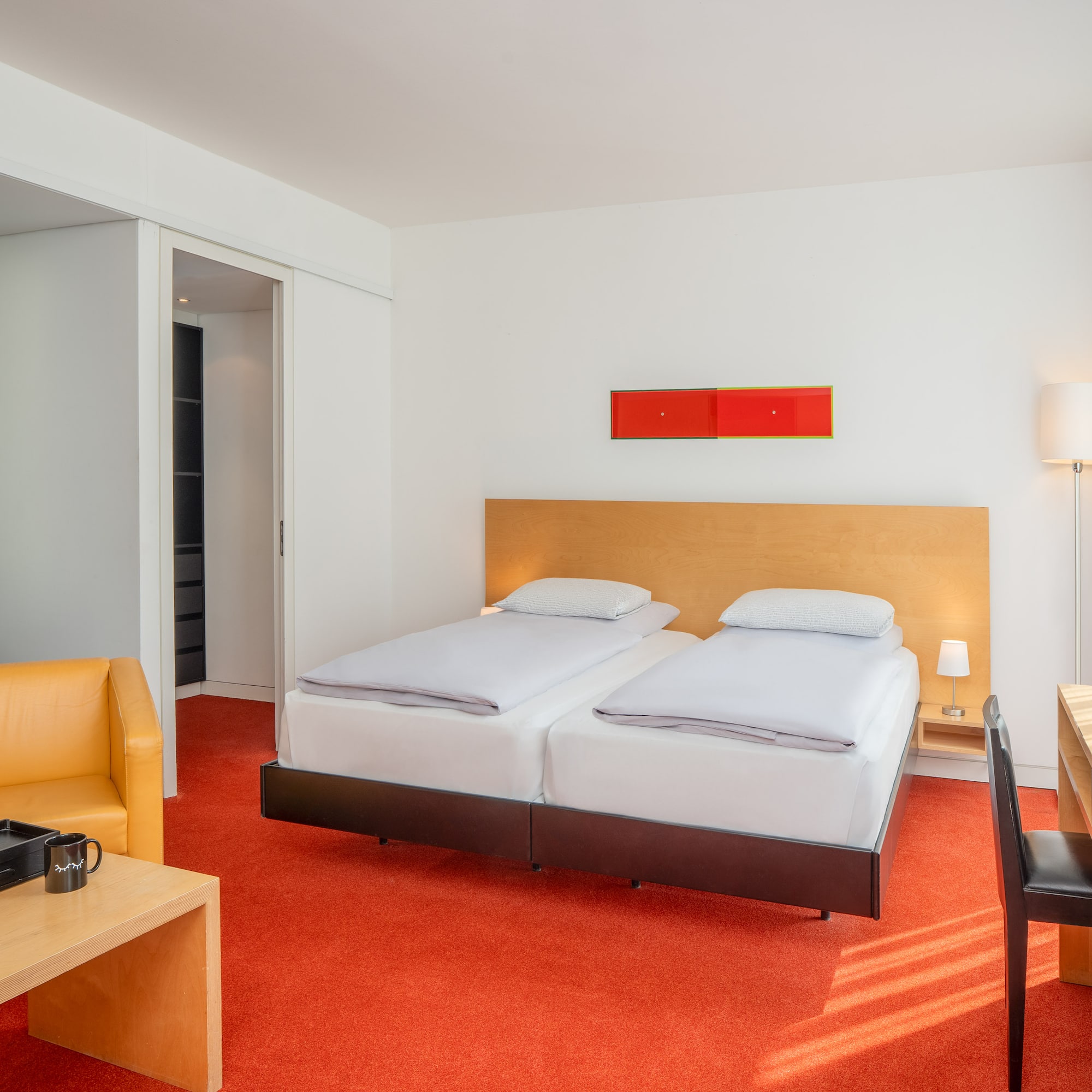 a room with two beds and a desk