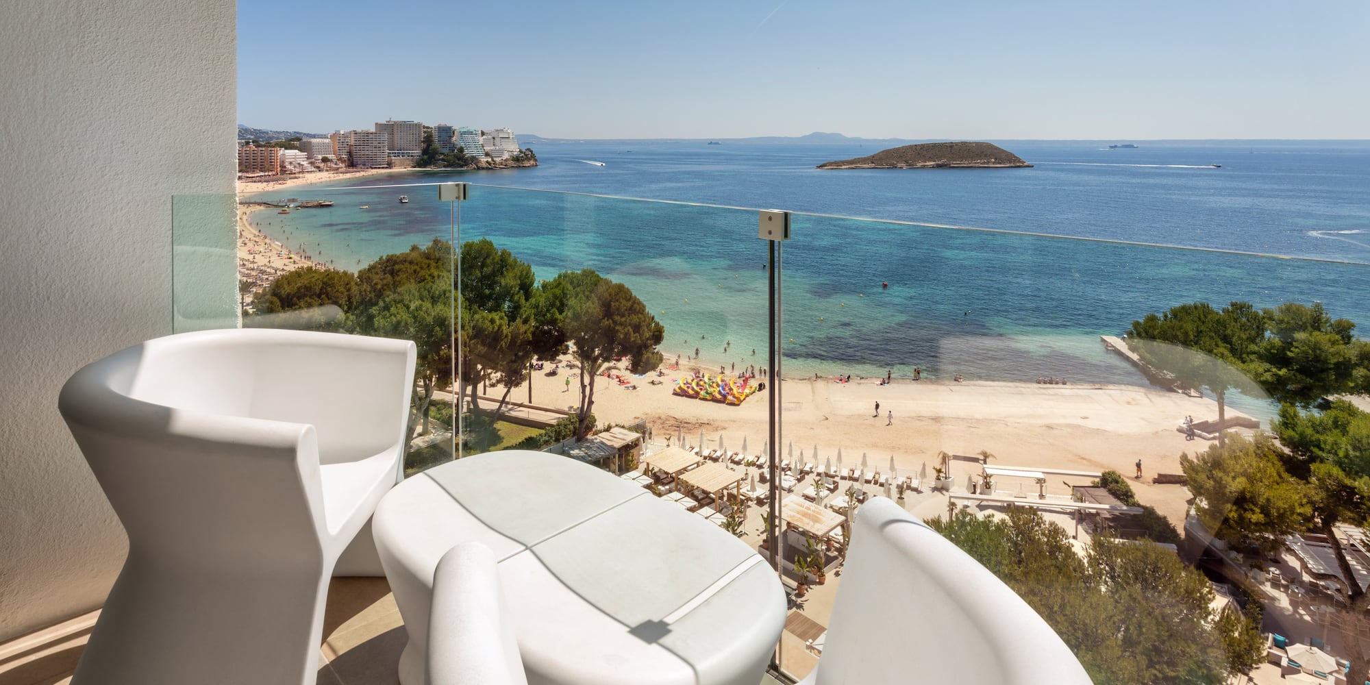 a balcony with chairs and a beach view