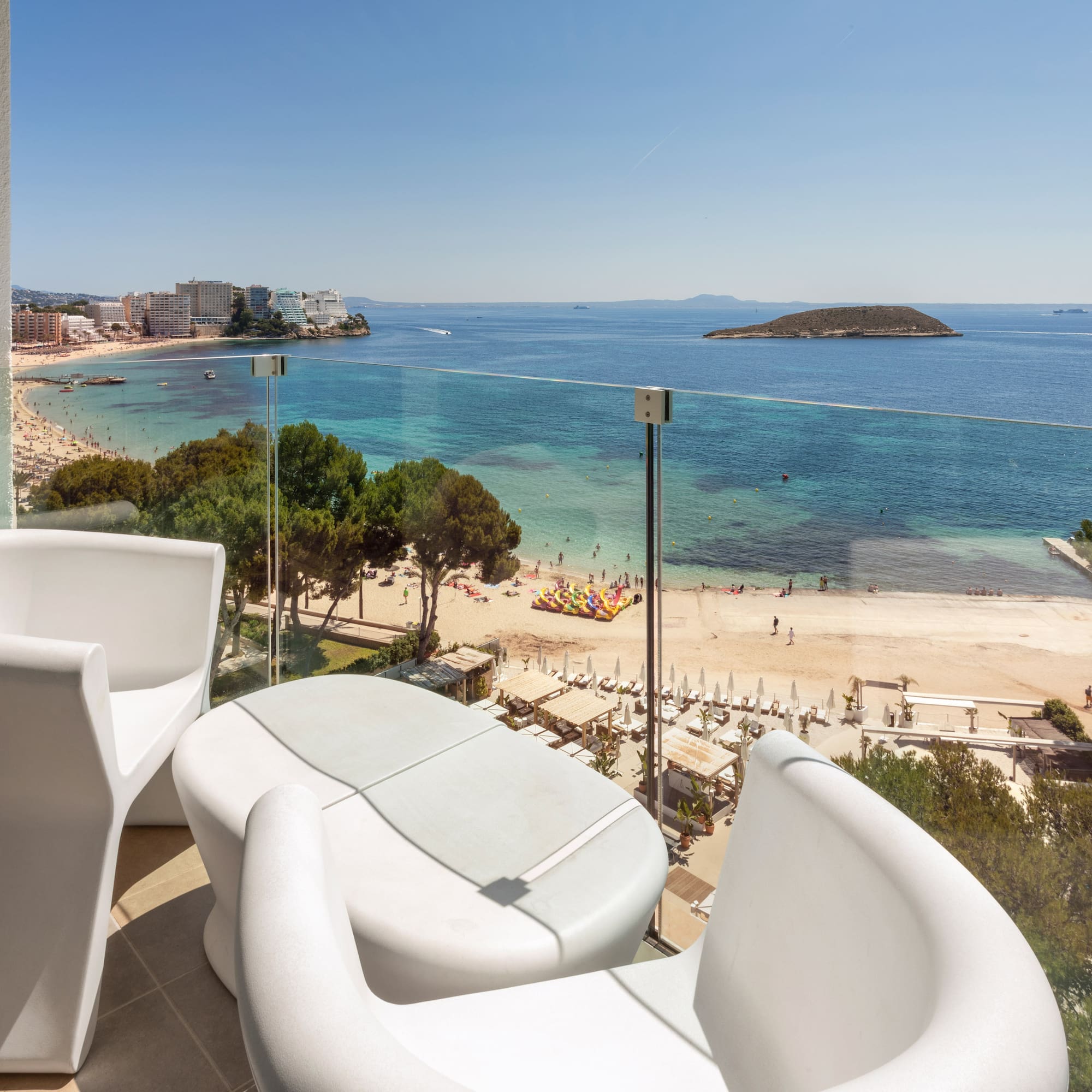 a balcony with chairs and a beach view