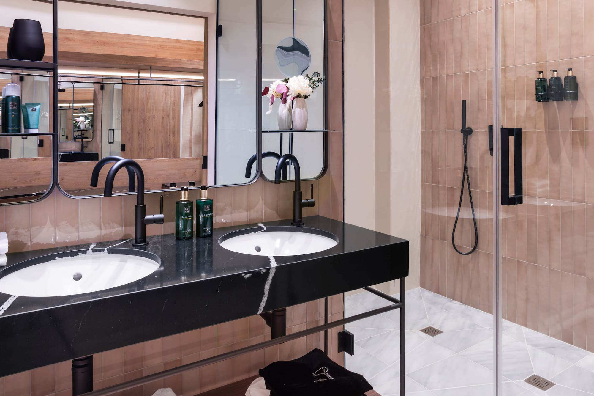 a bathroom with a shower and two sinks