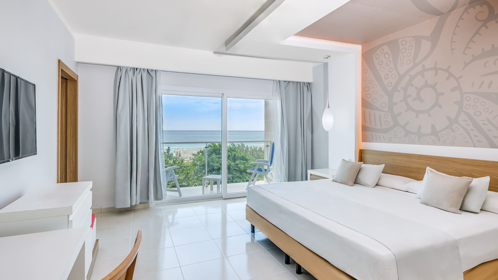 a bedroom with a large window and a view of the ocean