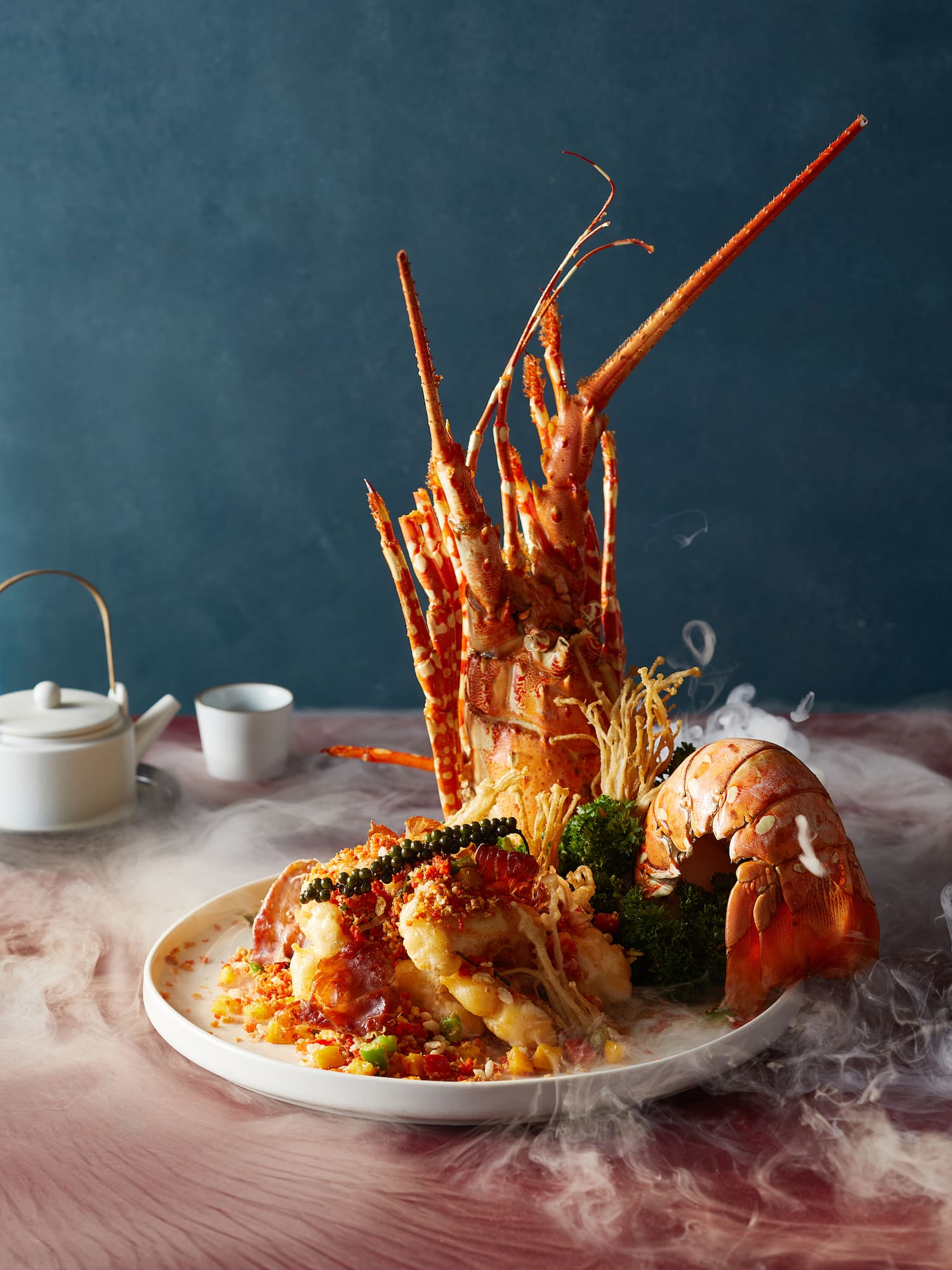 a plate of seafood with a teapot and saucer