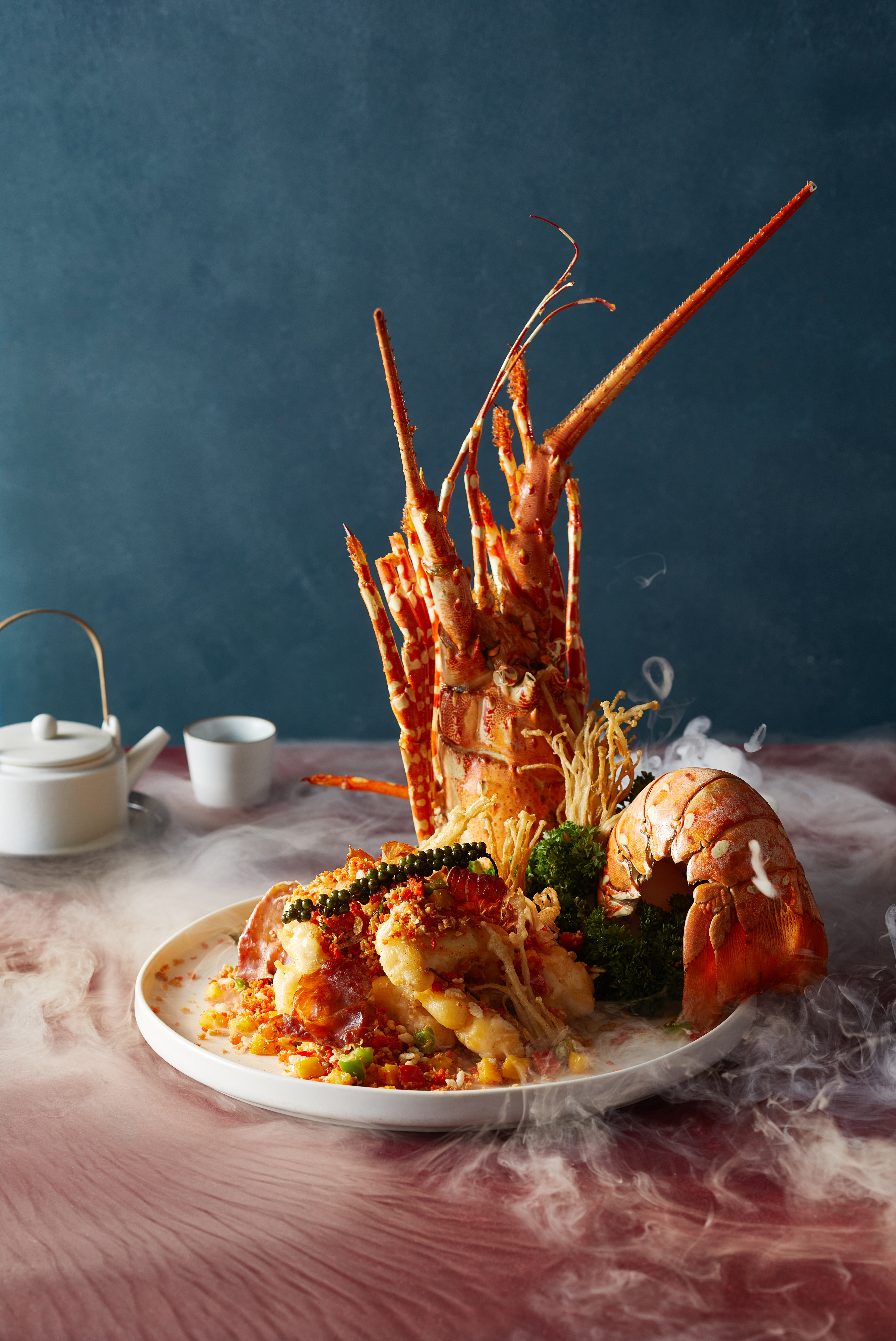 a plate of seafood with a teapot and saucer
