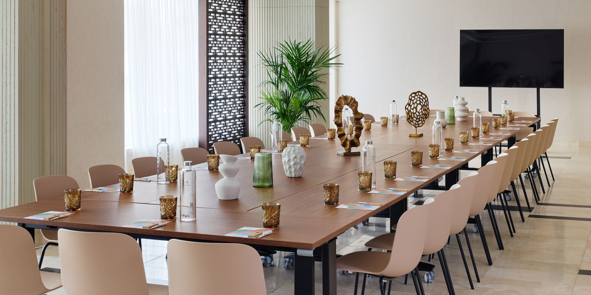 a long table with chairs and vases on it