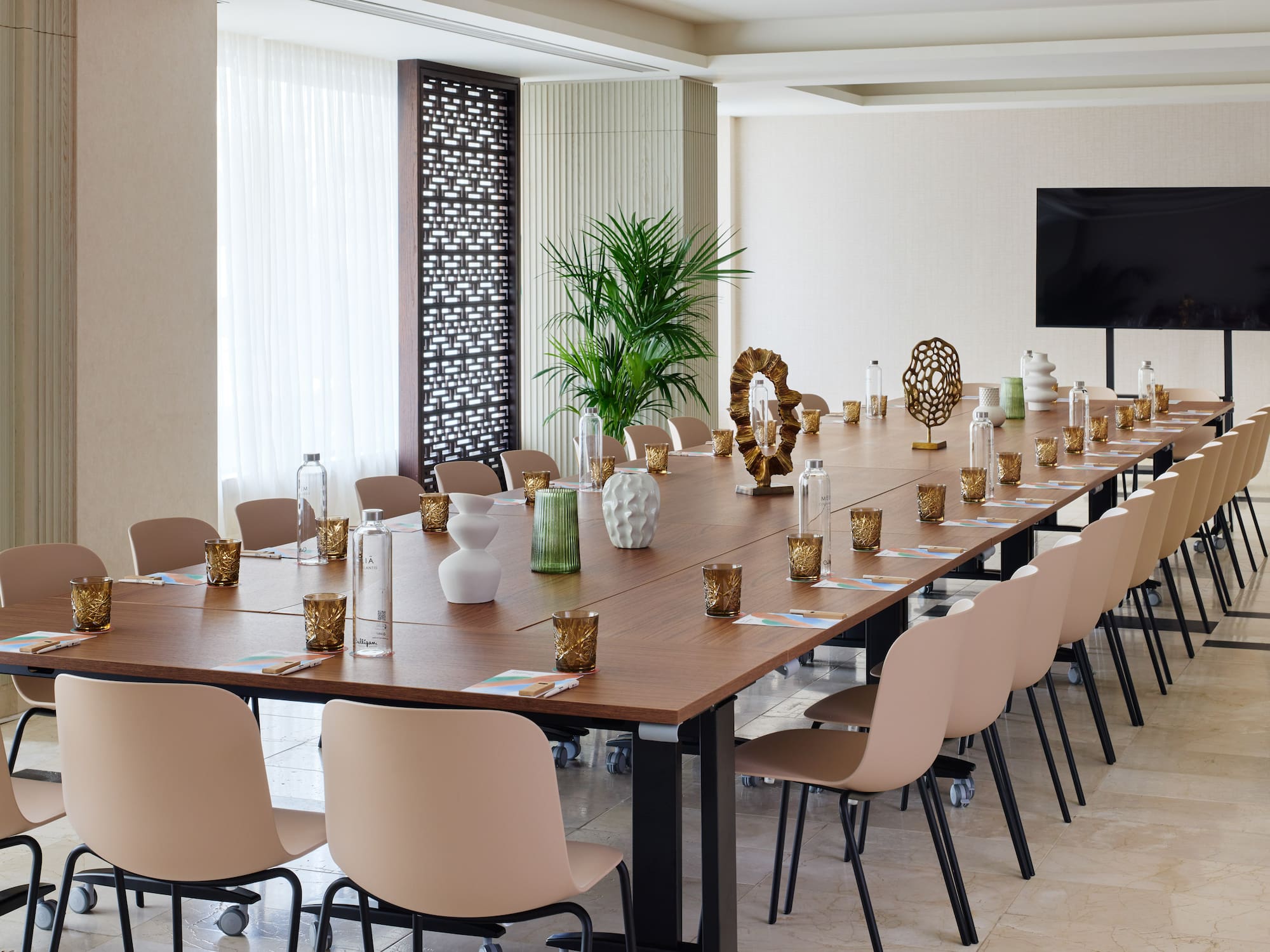 a long table with chairs and vases on it