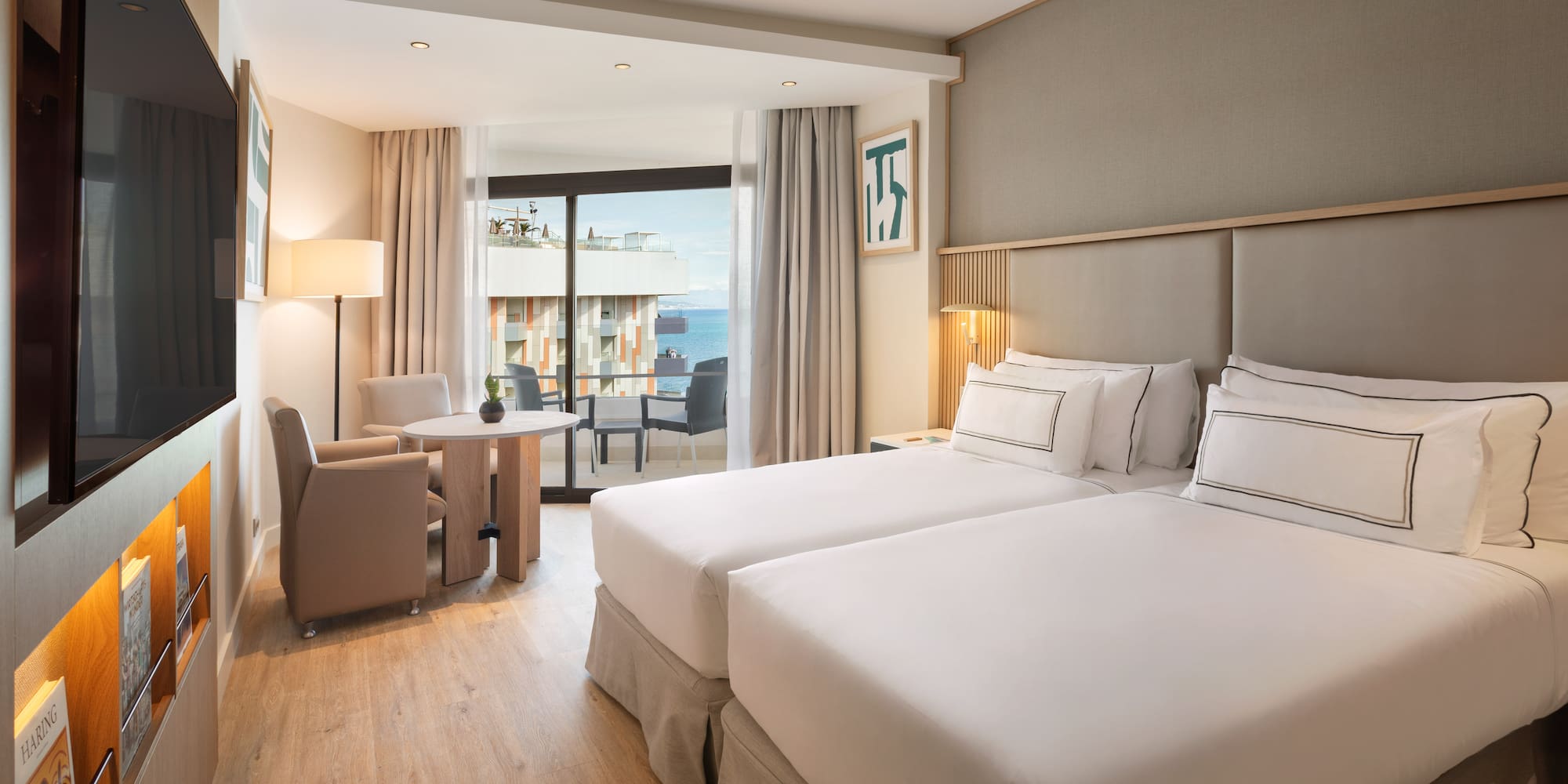 a room with two beds and a table and chairs