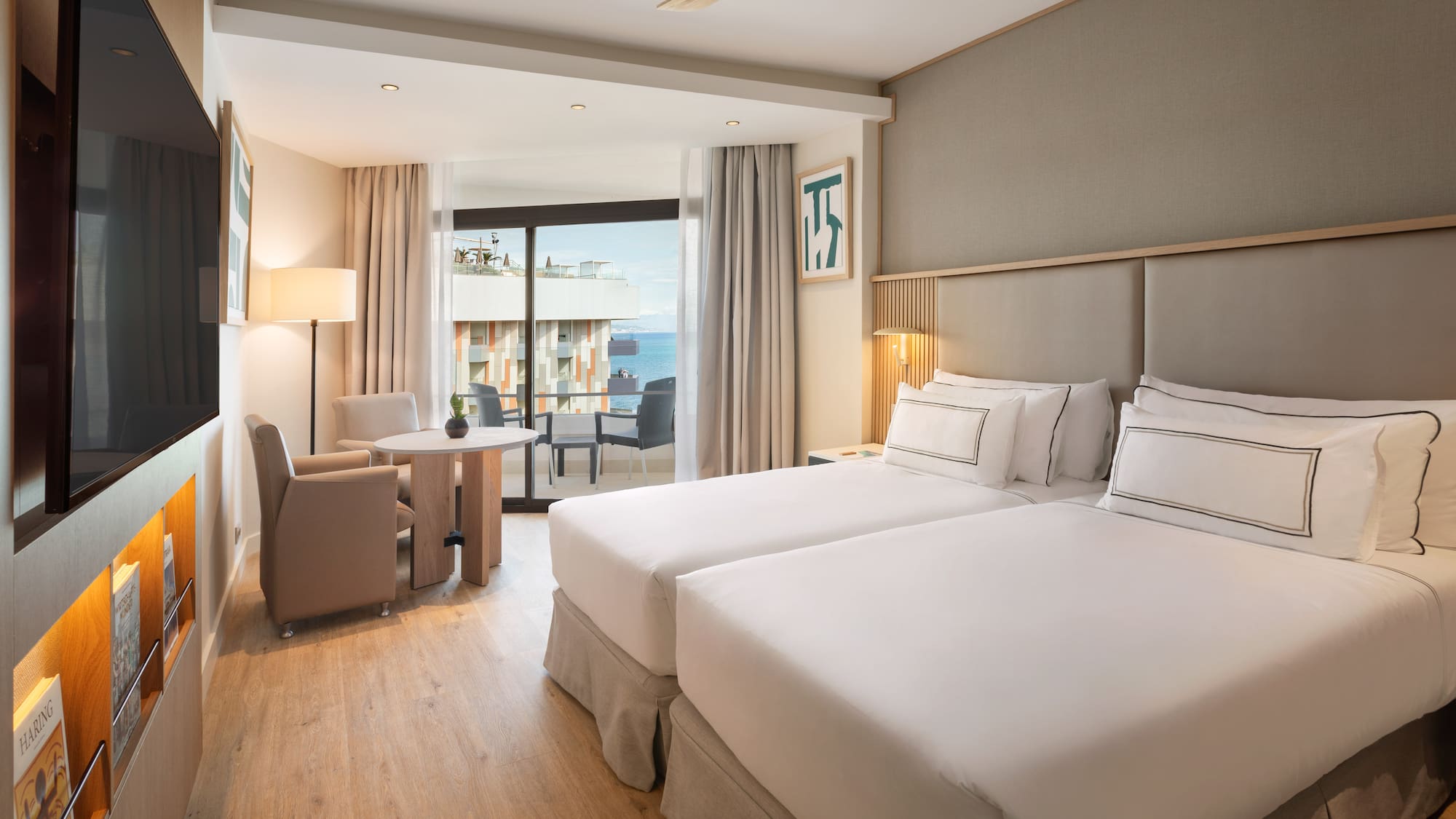 a room with two beds and a table and chairs