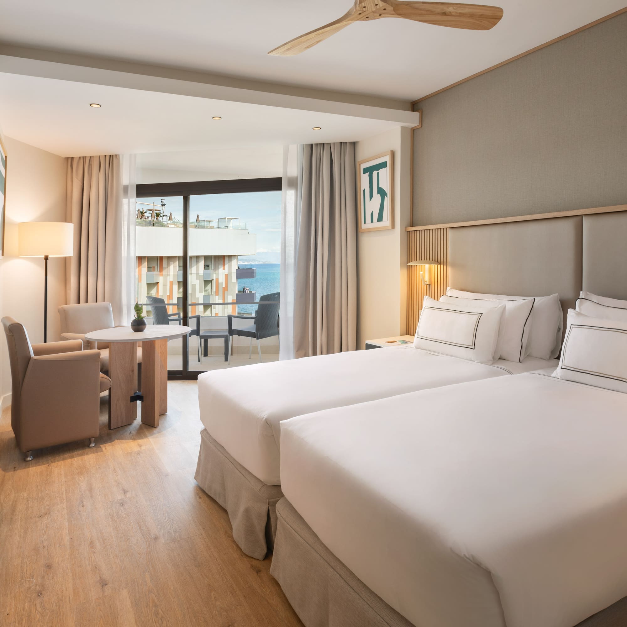 a room with two beds and a table and chairs