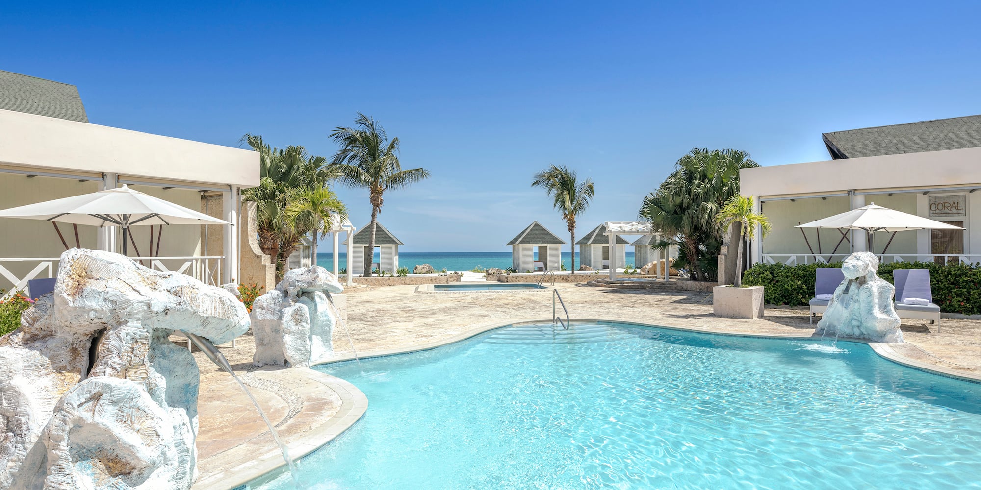 a swimming pool with a fountain and palm trees