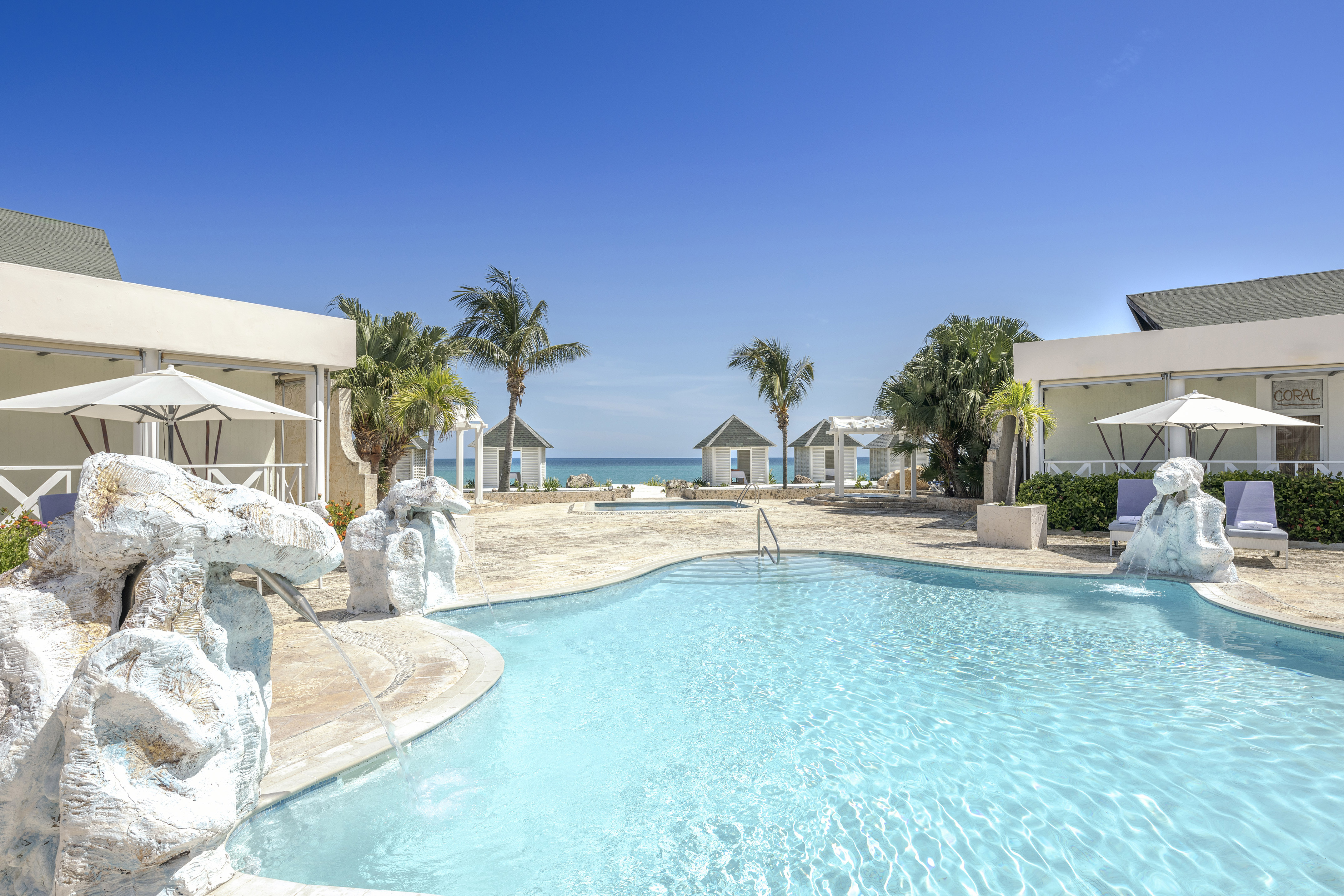 a swimming pool with a fountain and palm trees