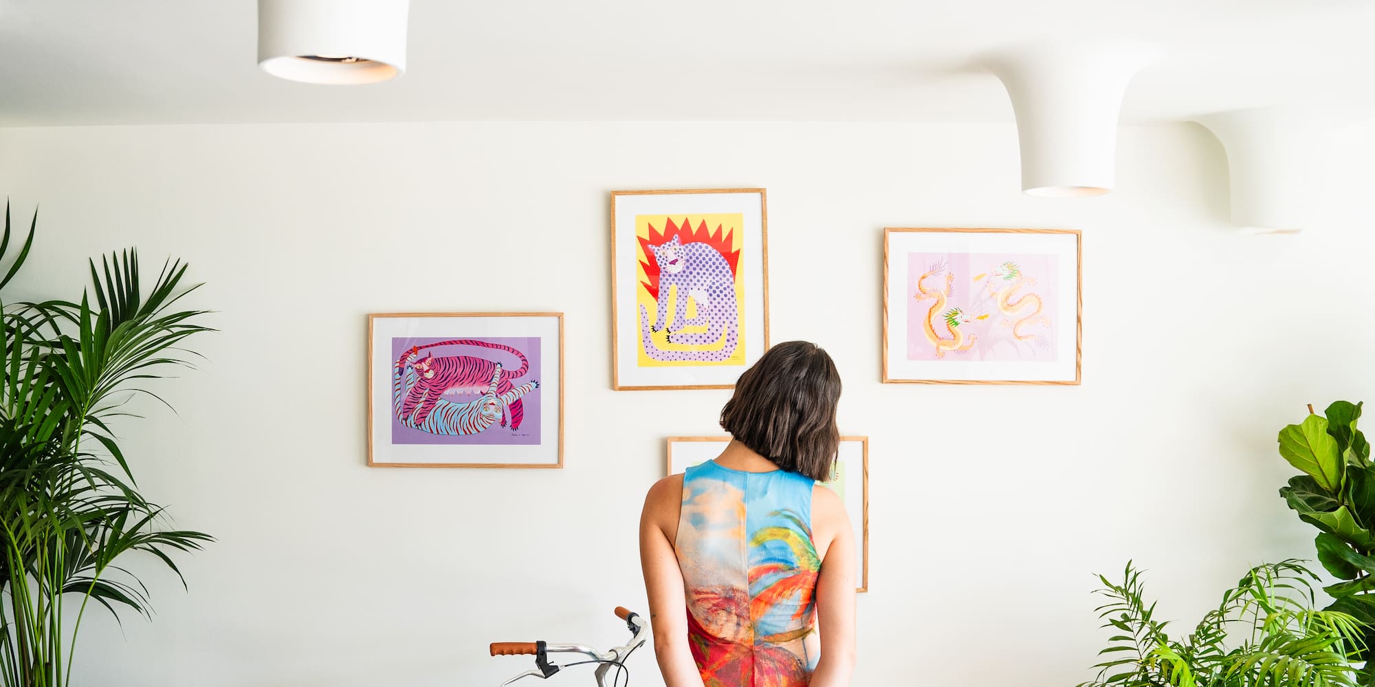 a woman standing in front of a blue bicycle and a dog