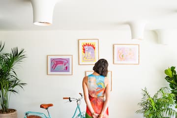 a woman standing in front of a blue bicycle and a dog