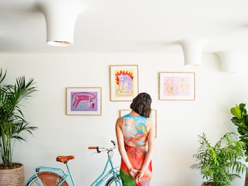 a woman standing in front of a blue bicycle and a dog