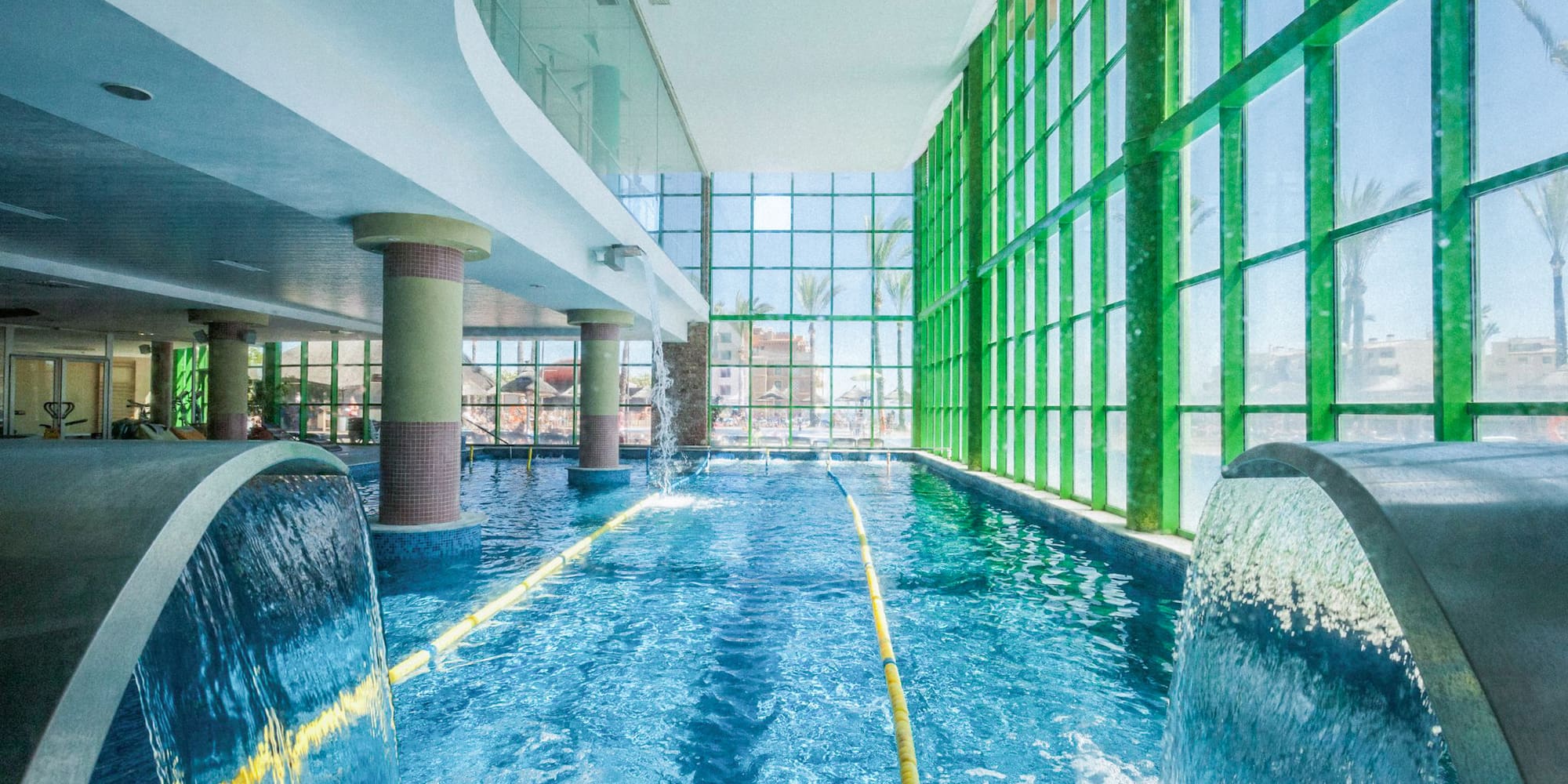 a swimming pool with water and large windows