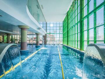 a swimming pool with water and large windows