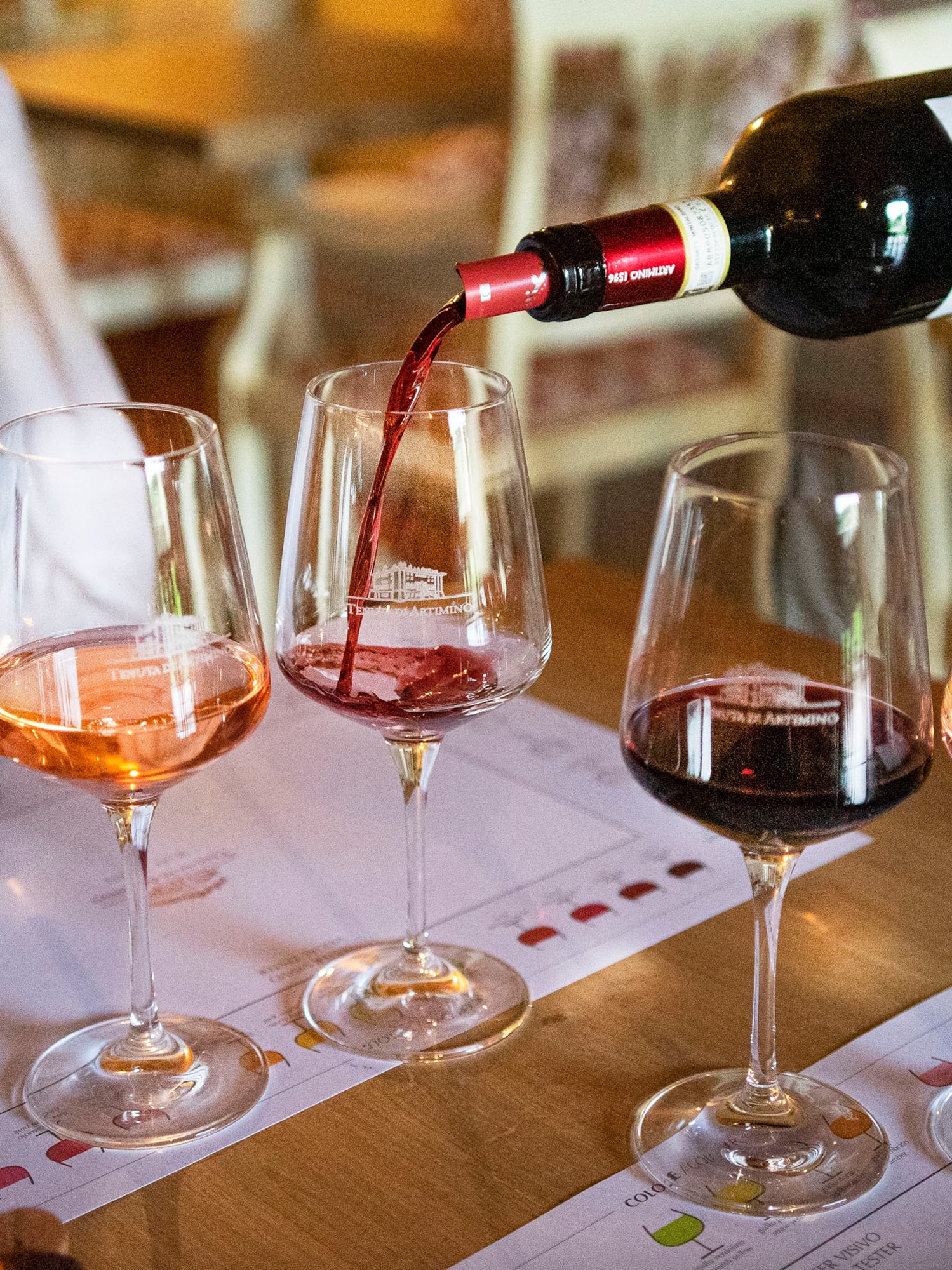 Hand pouring Tenuta Artimino Chianti red wine at a multi-varietal tasting.