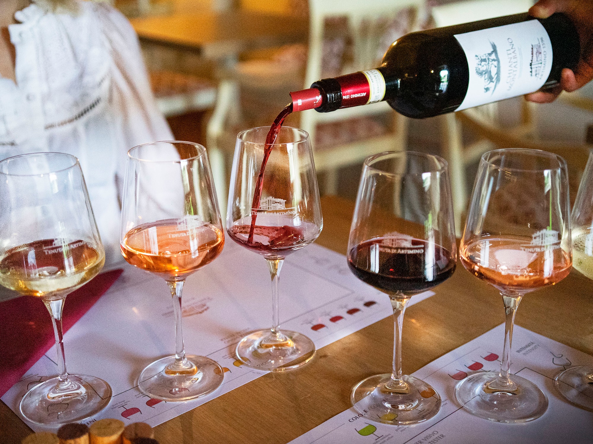 Hand pouring Tenuta Artimino Chianti red wine at a multi-varietal tasting.