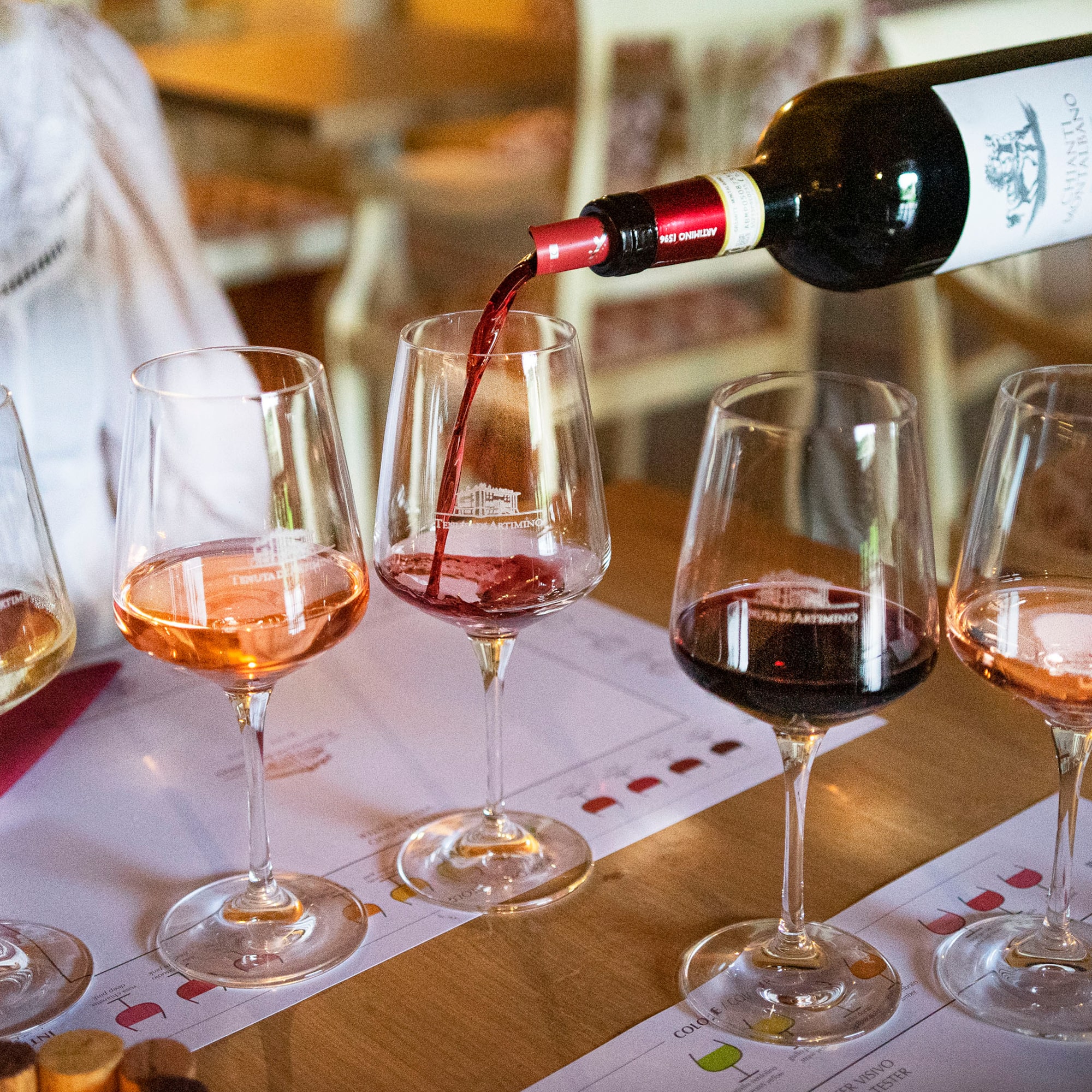 Hand pouring Tenuta Artimino Chianti red wine at a multi-varietal tasting.