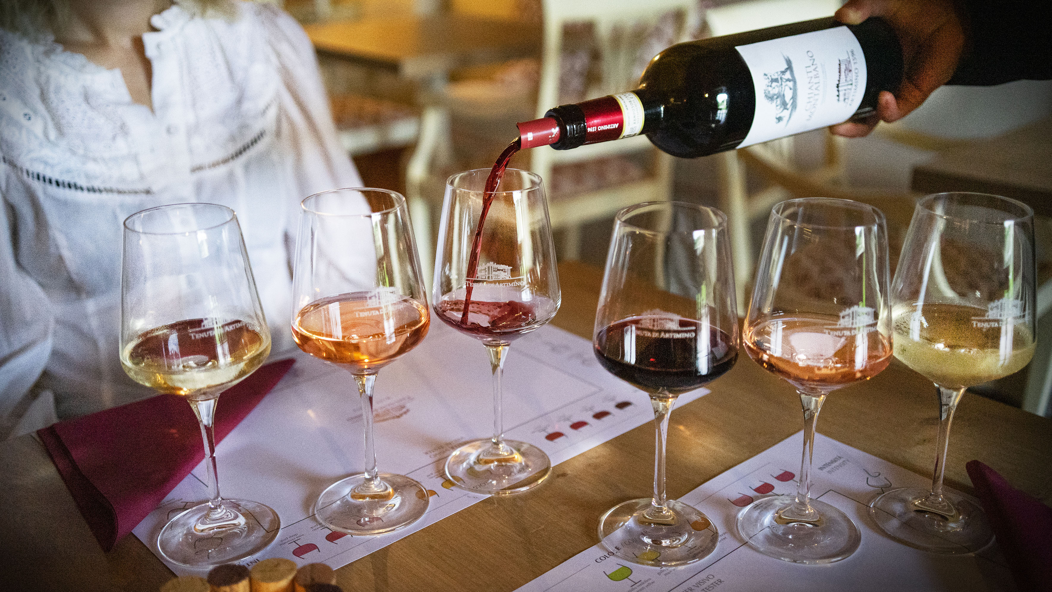 Hand pouring Tenuta Artimino Chianti red wine at a multi-varietal tasting.