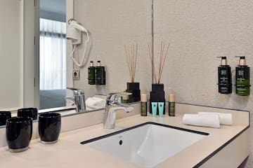 a bathroom sink with a mirror and a black cup on it