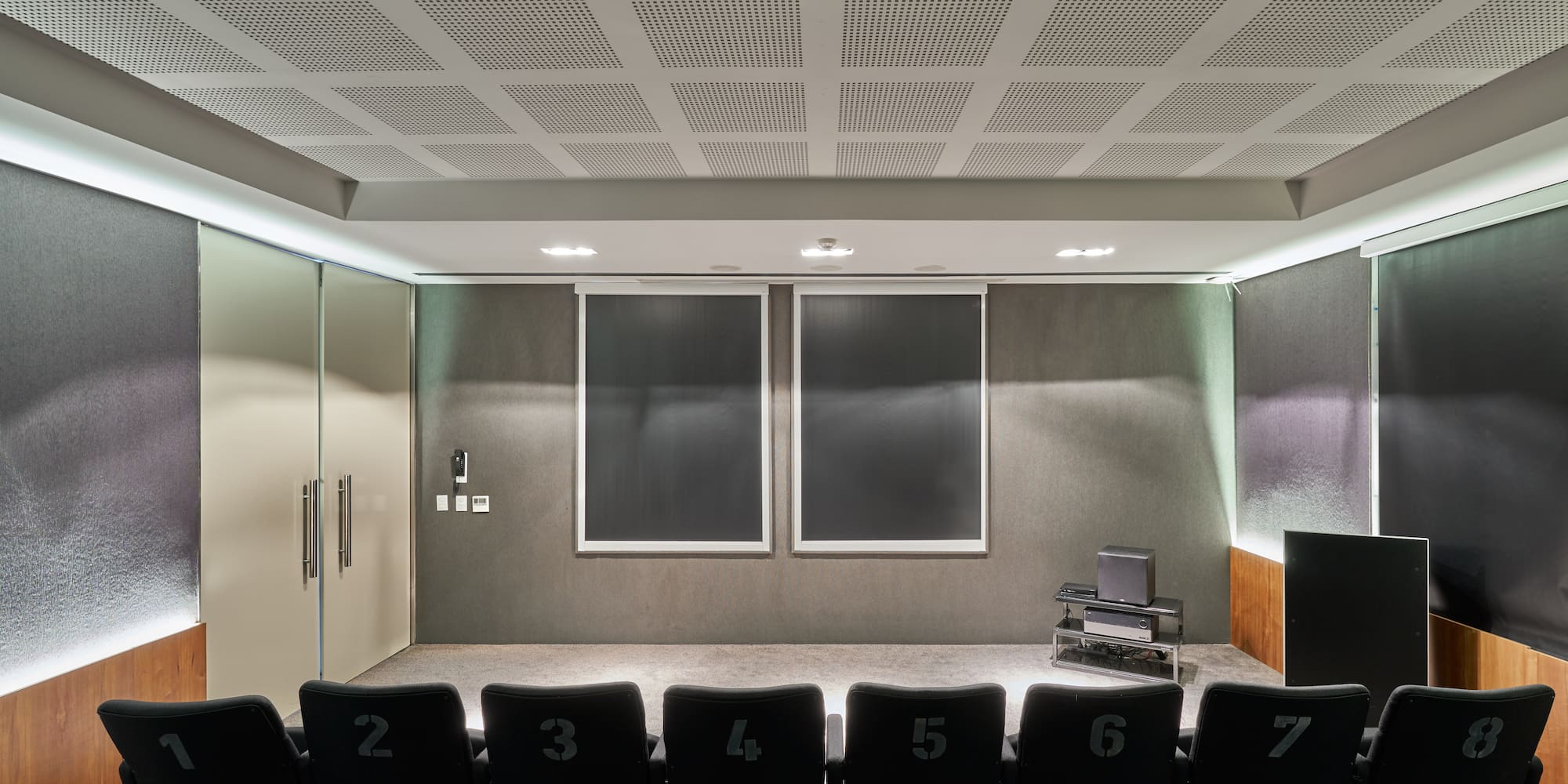 a room with a row of chairs and a screen