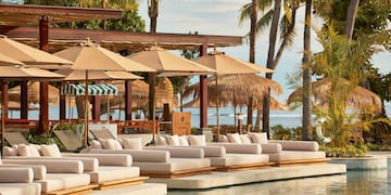 a pool with lounge chairs and umbrellas