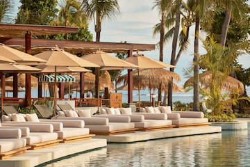 a pool with lounge chairs and umbrellas