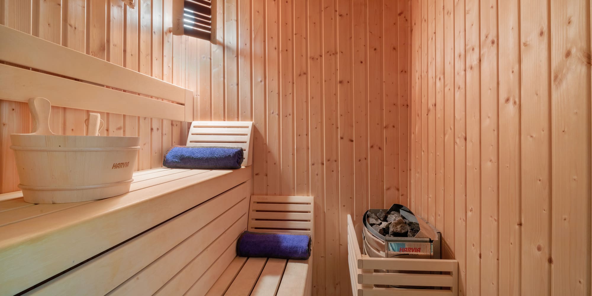 a wooden sauna with a bench and basket