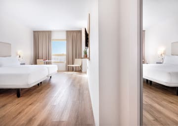 a room with two beds and a wood floor