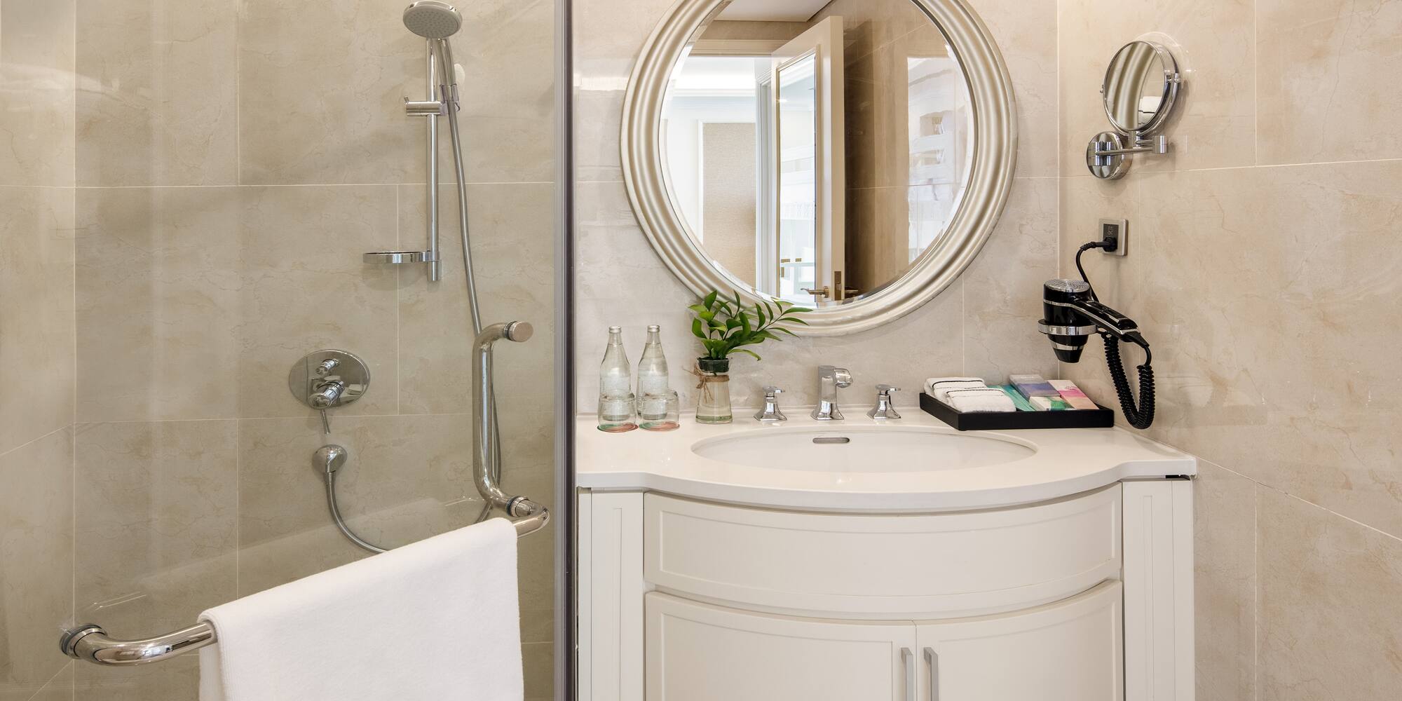 a bathroom with a round mirror and shower