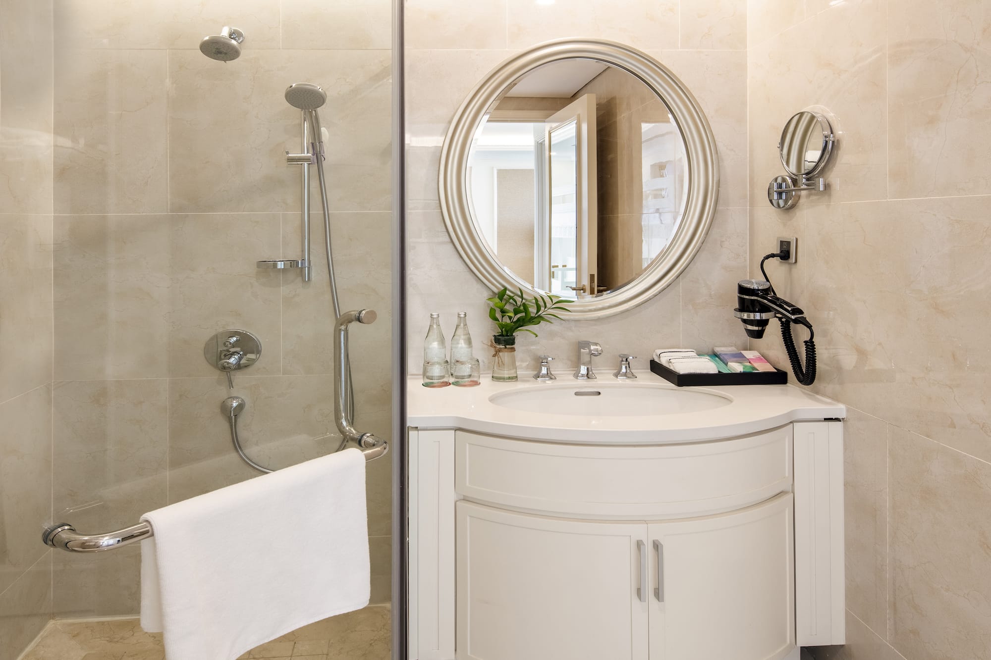 a bathroom with a round mirror and shower