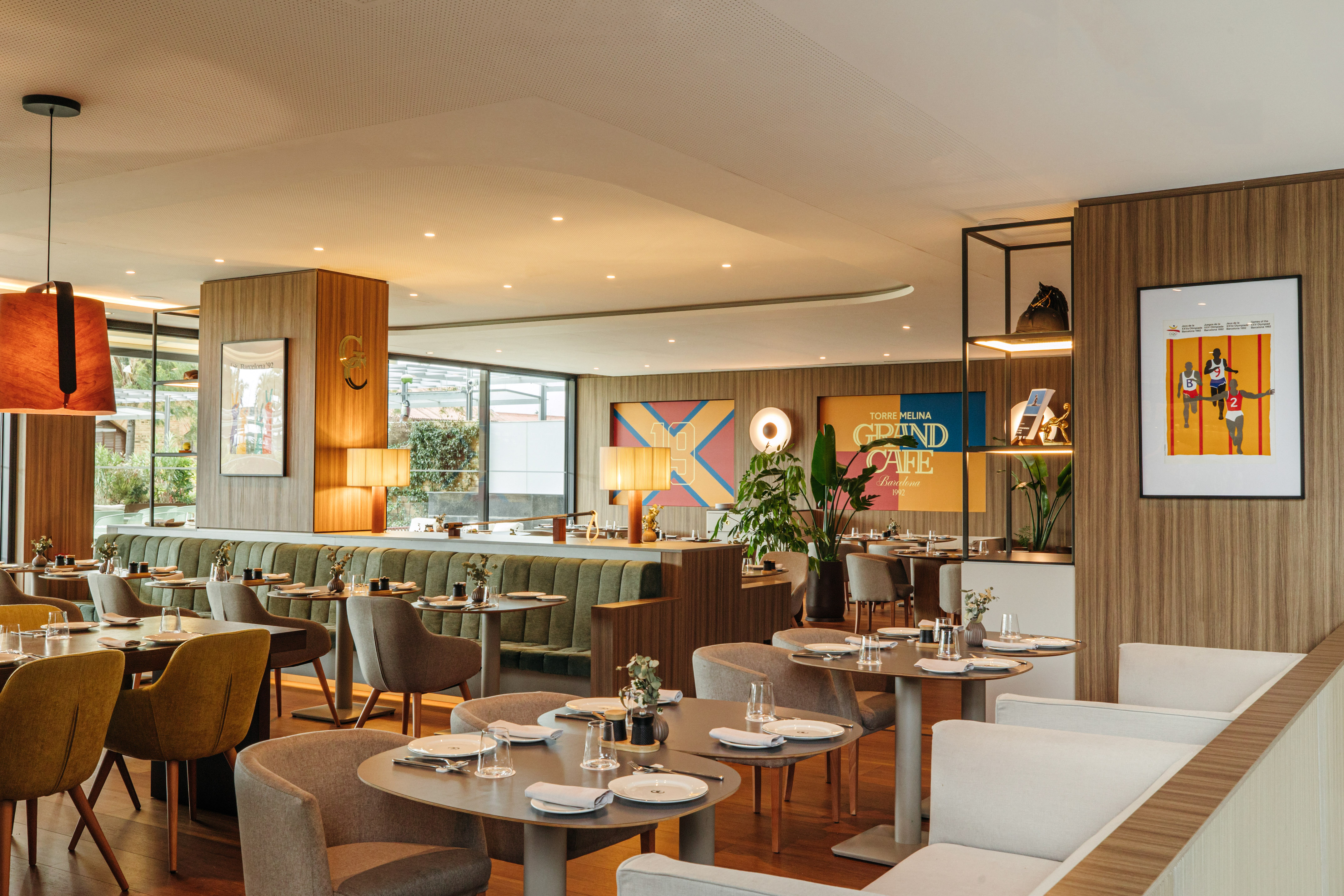 Modern Barcelona cafe interior with wood panels and diverse seating.