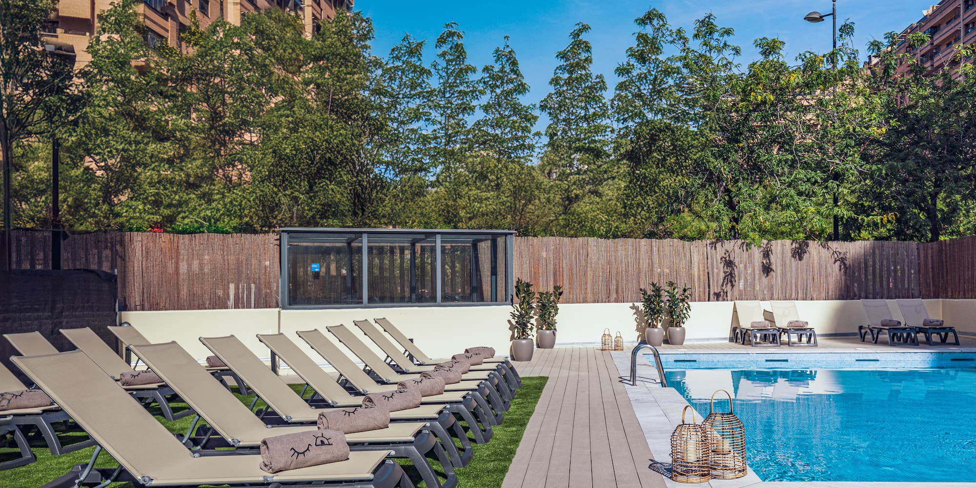 a pool with lounge chairs and a wood deck