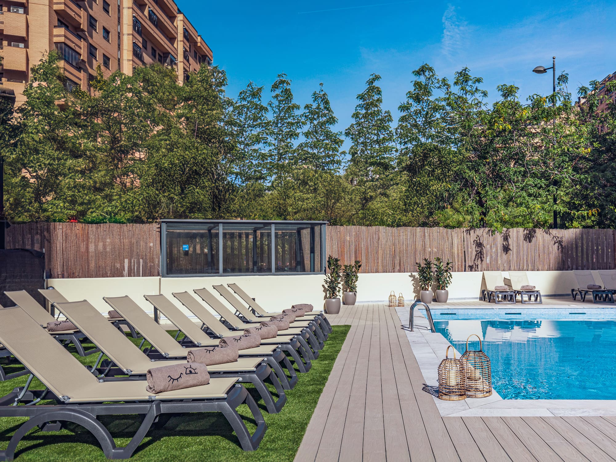 a pool with lounge chairs and a wood deck